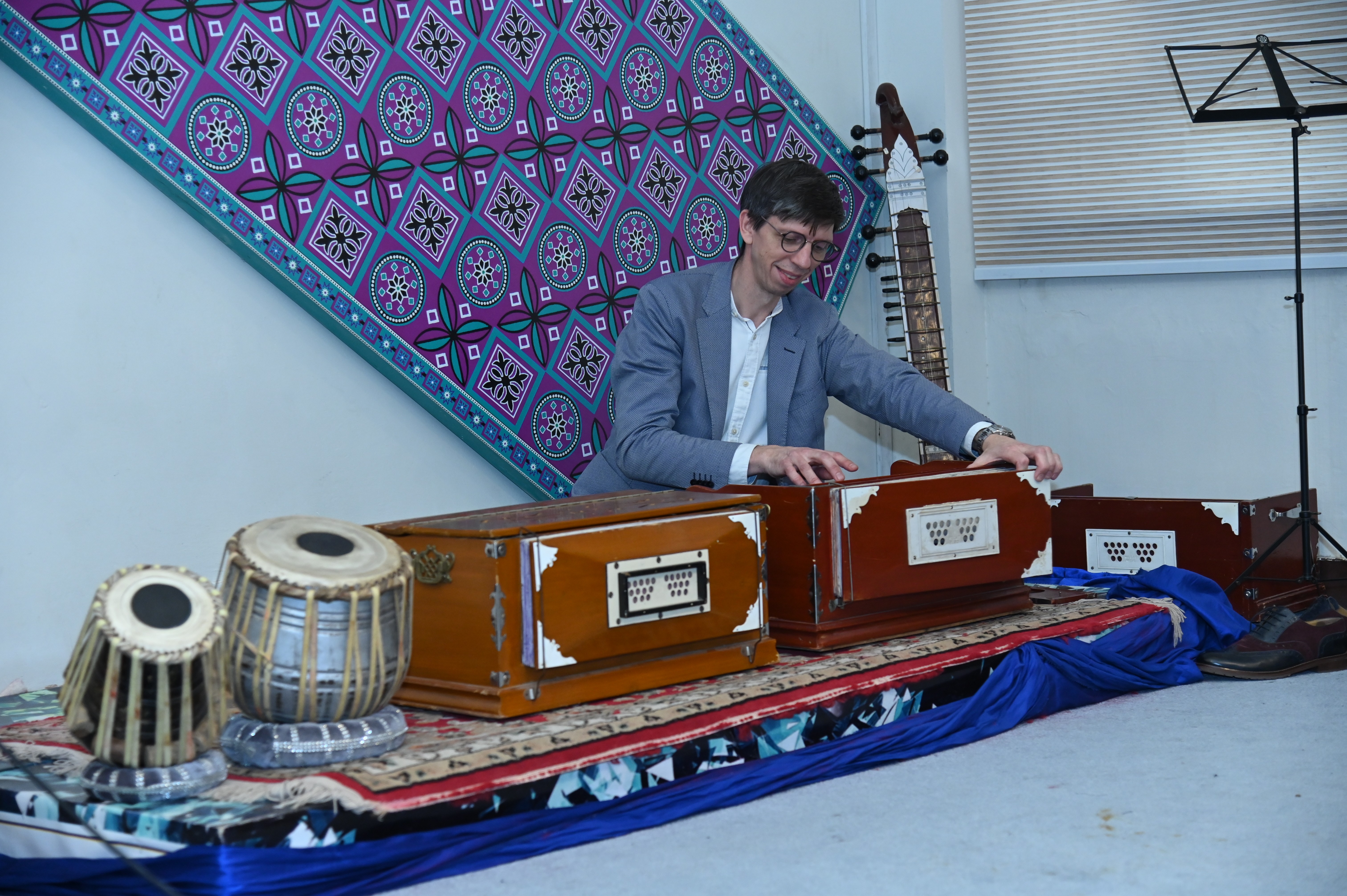 an artist playing Harmonium, free-reed keyboard instrument that produces sound when wind sent by foot-operated below through a pressure-equalizing air reservoir at PNCA