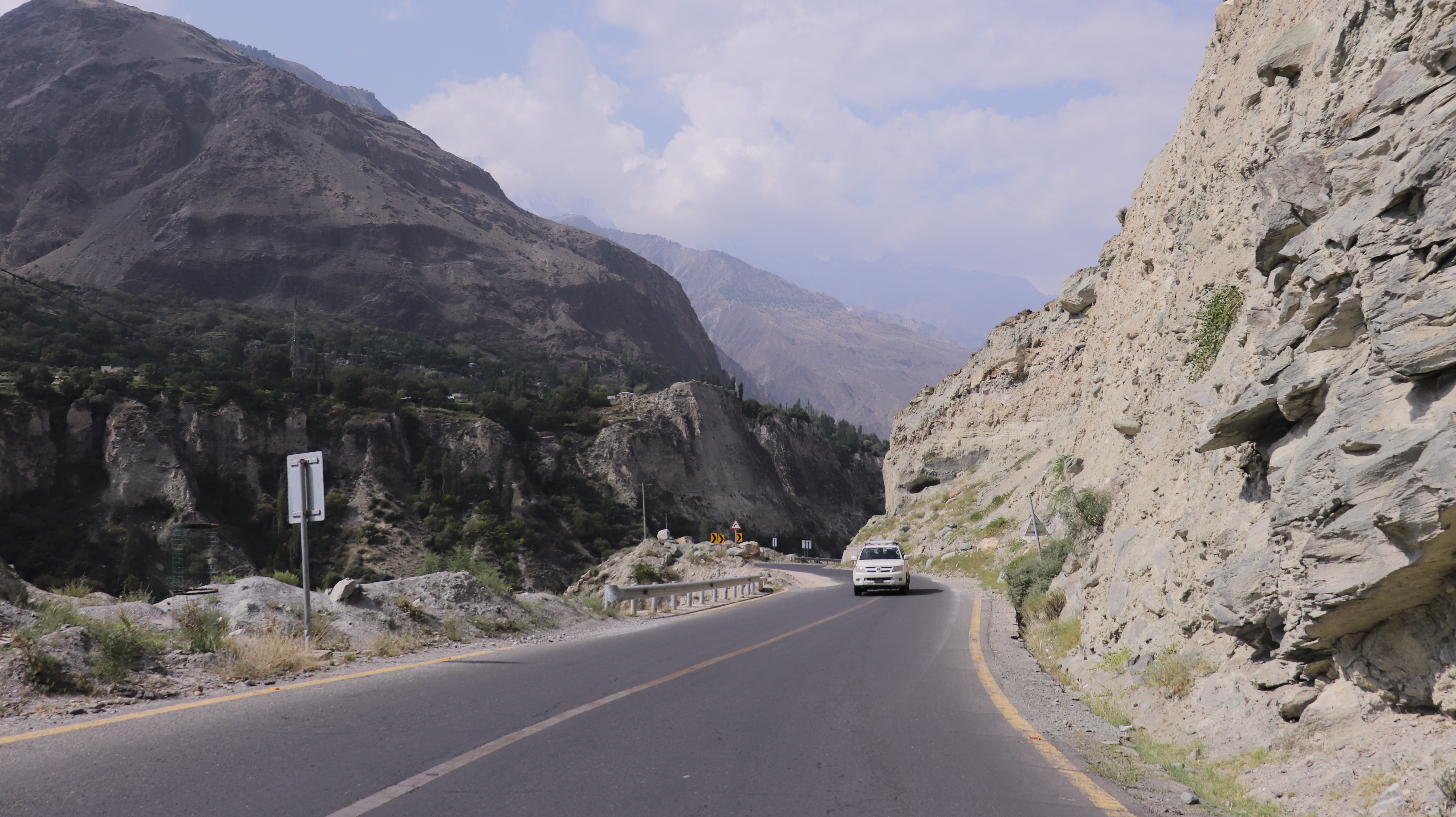 A car passing by the spectacular zigzag mountain road around Passu Sar Peak