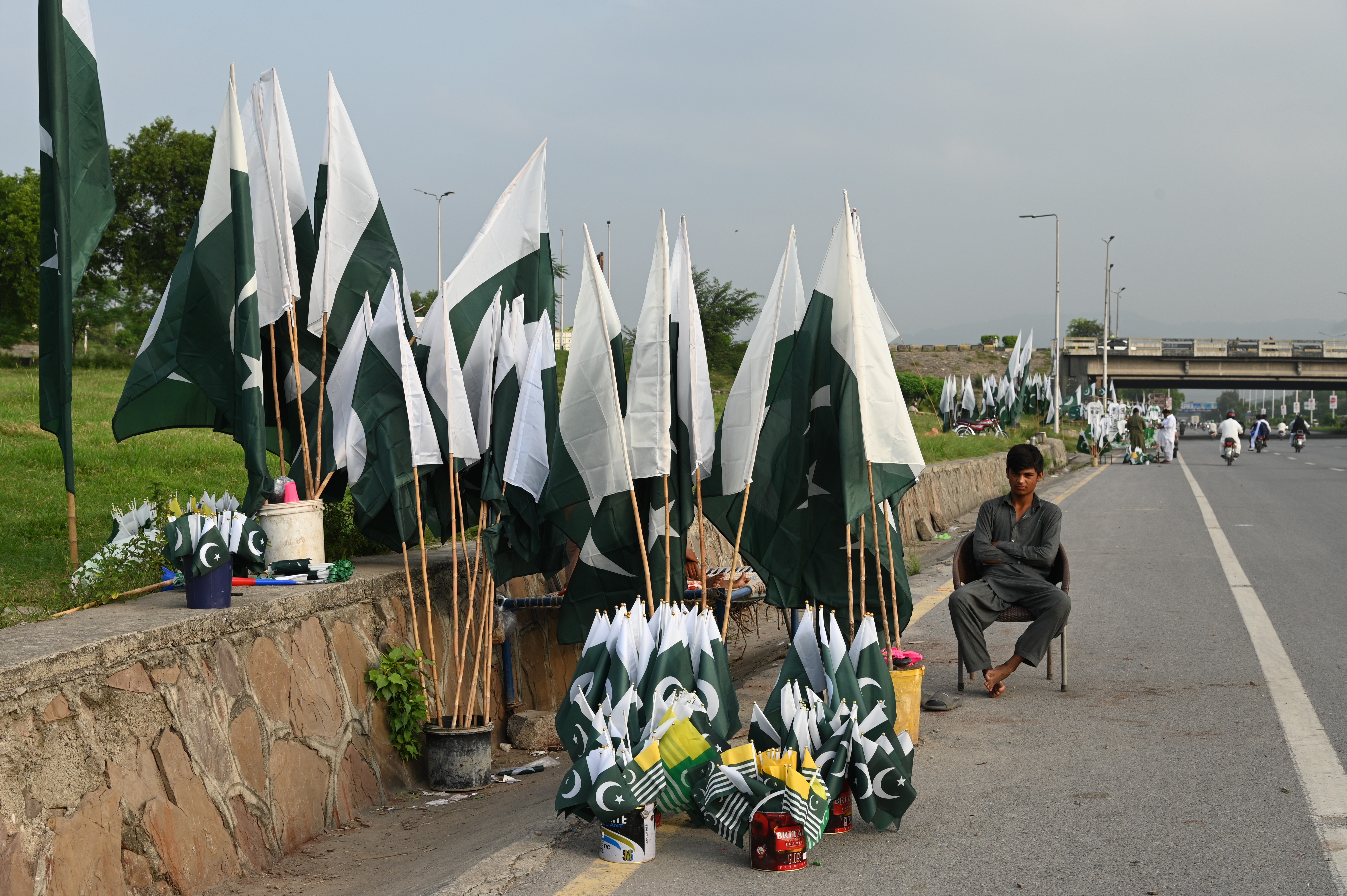 A boy set up stall selling national flags and badges of Pakistan and Kashmir in Islamabad to mark independence day