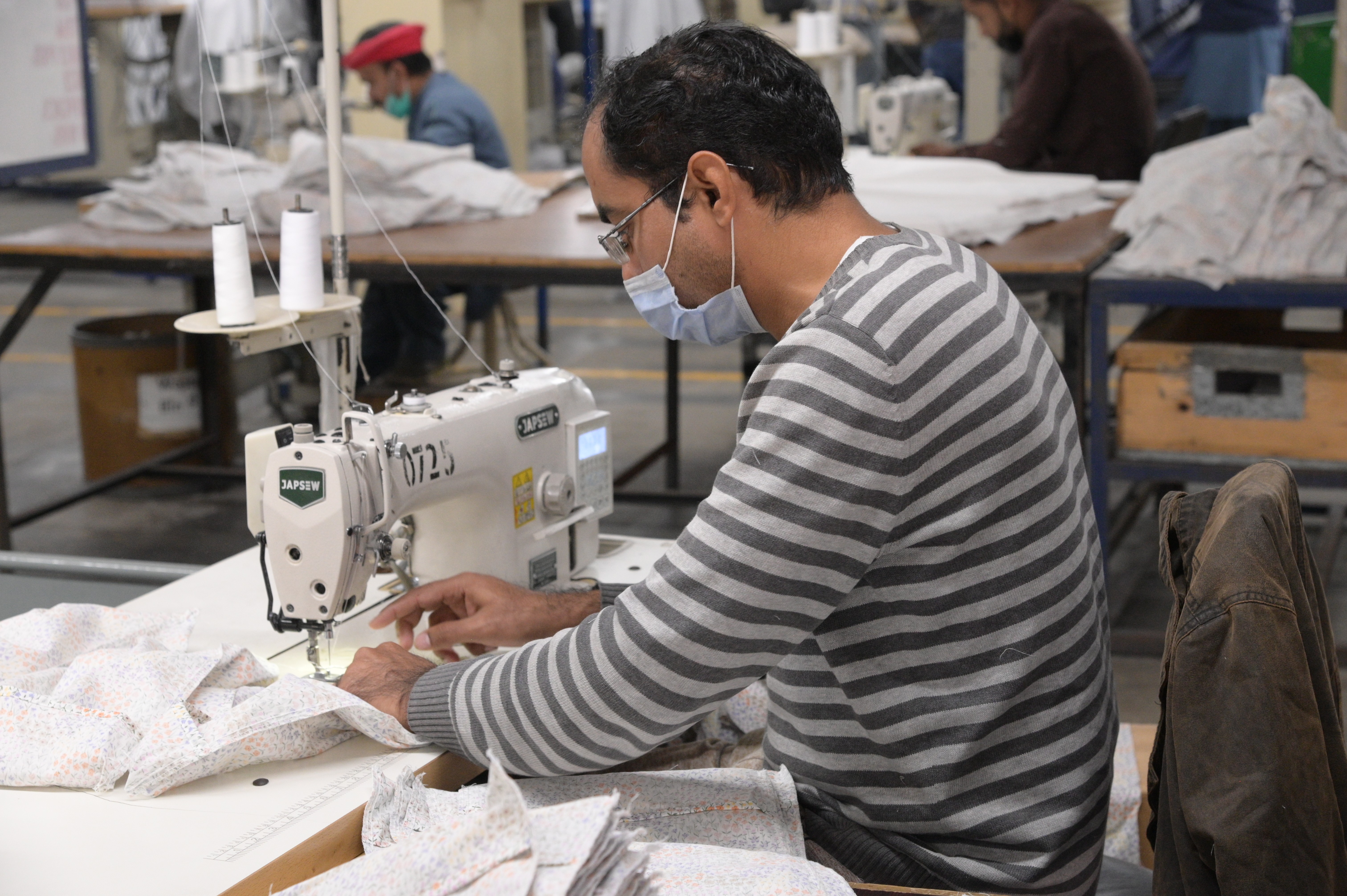 A man sewing cushion covers in the textile industry