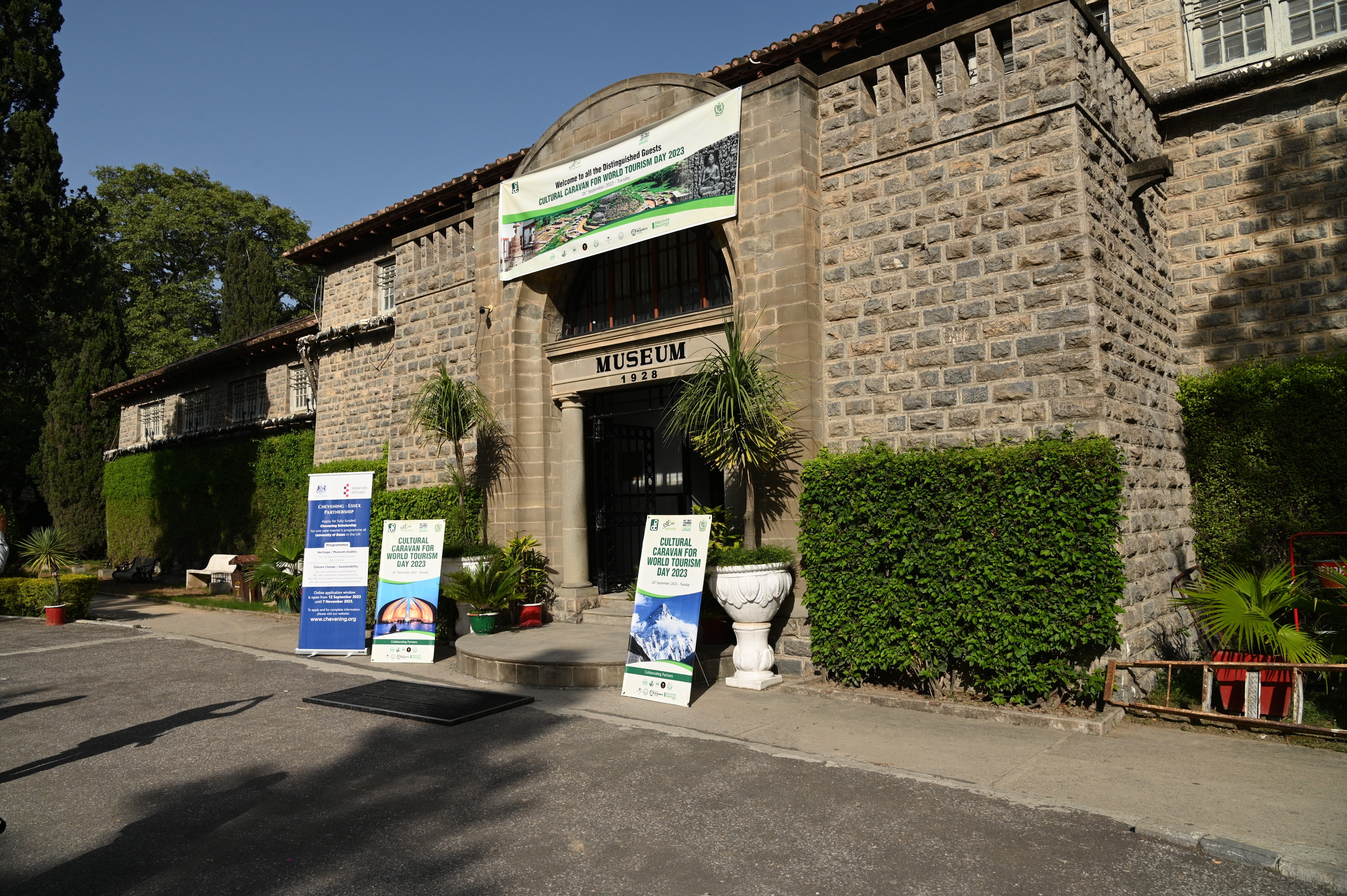 The main entrance of the taxila museum with large banners showing cultural caravan for world tourism day 2023