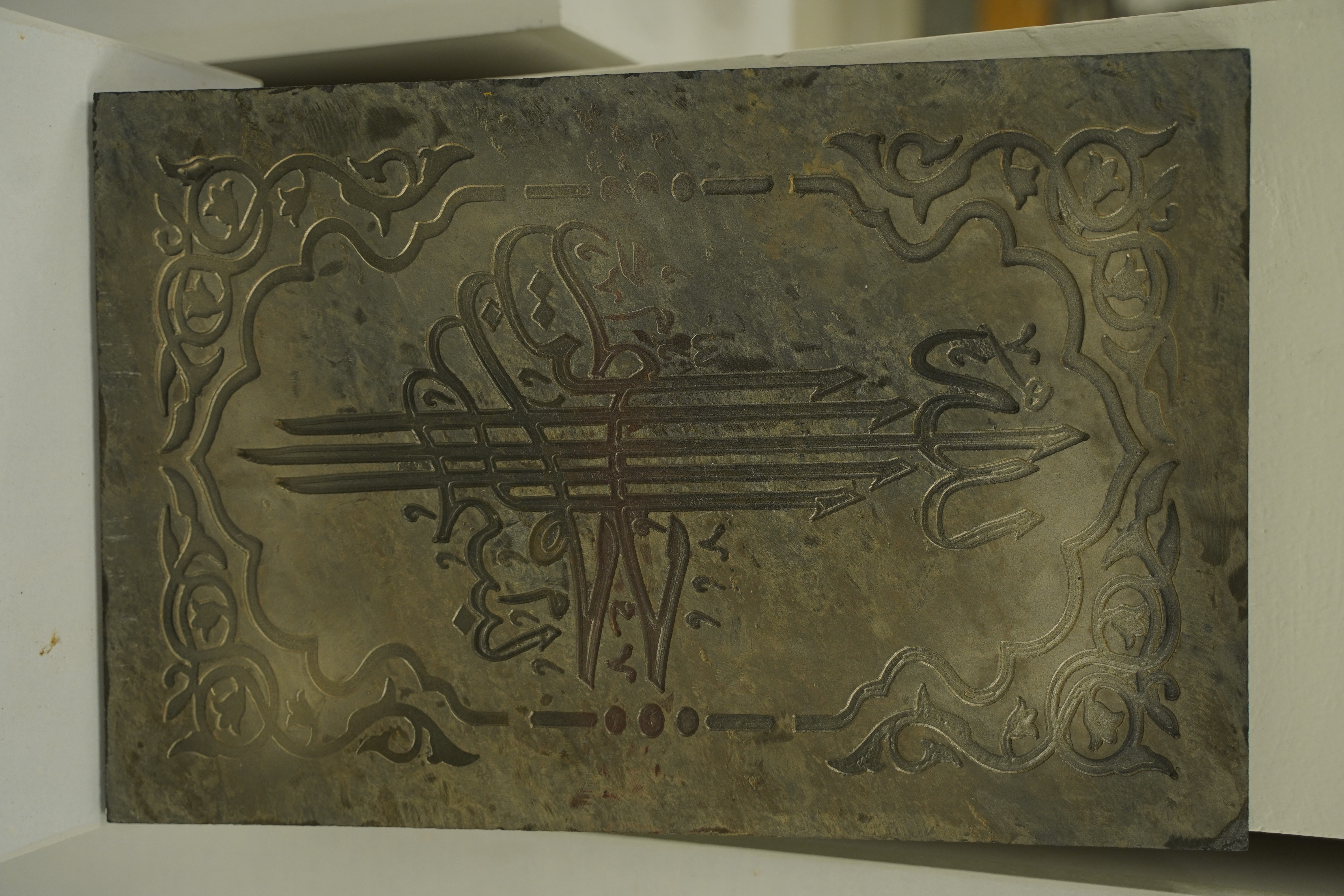 The metallic plate with engraved Arabic calligraphy