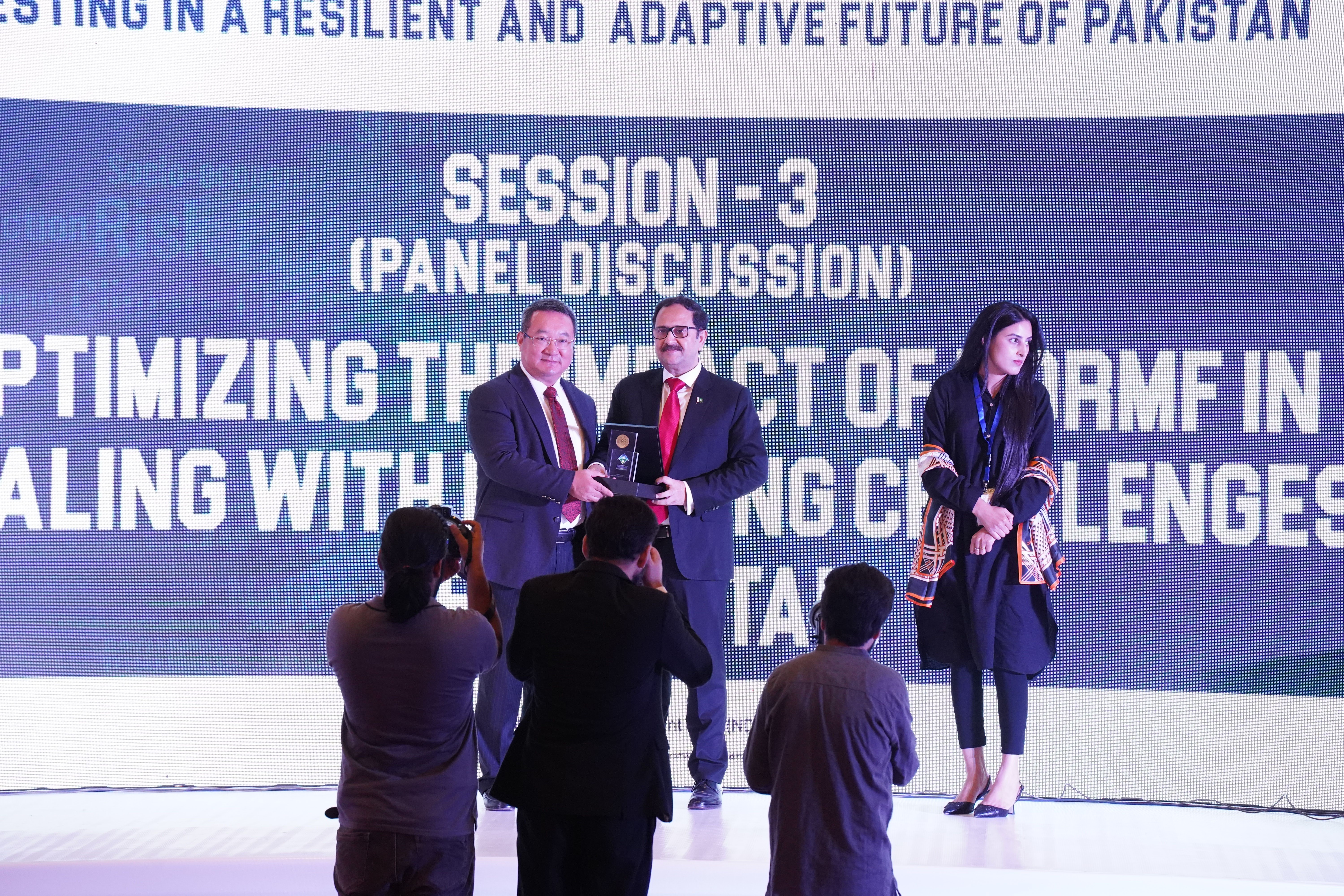Bilal Anwar distributing awards to the guests at a  conference held on investing in a resilient and adaptive future of Pakistan