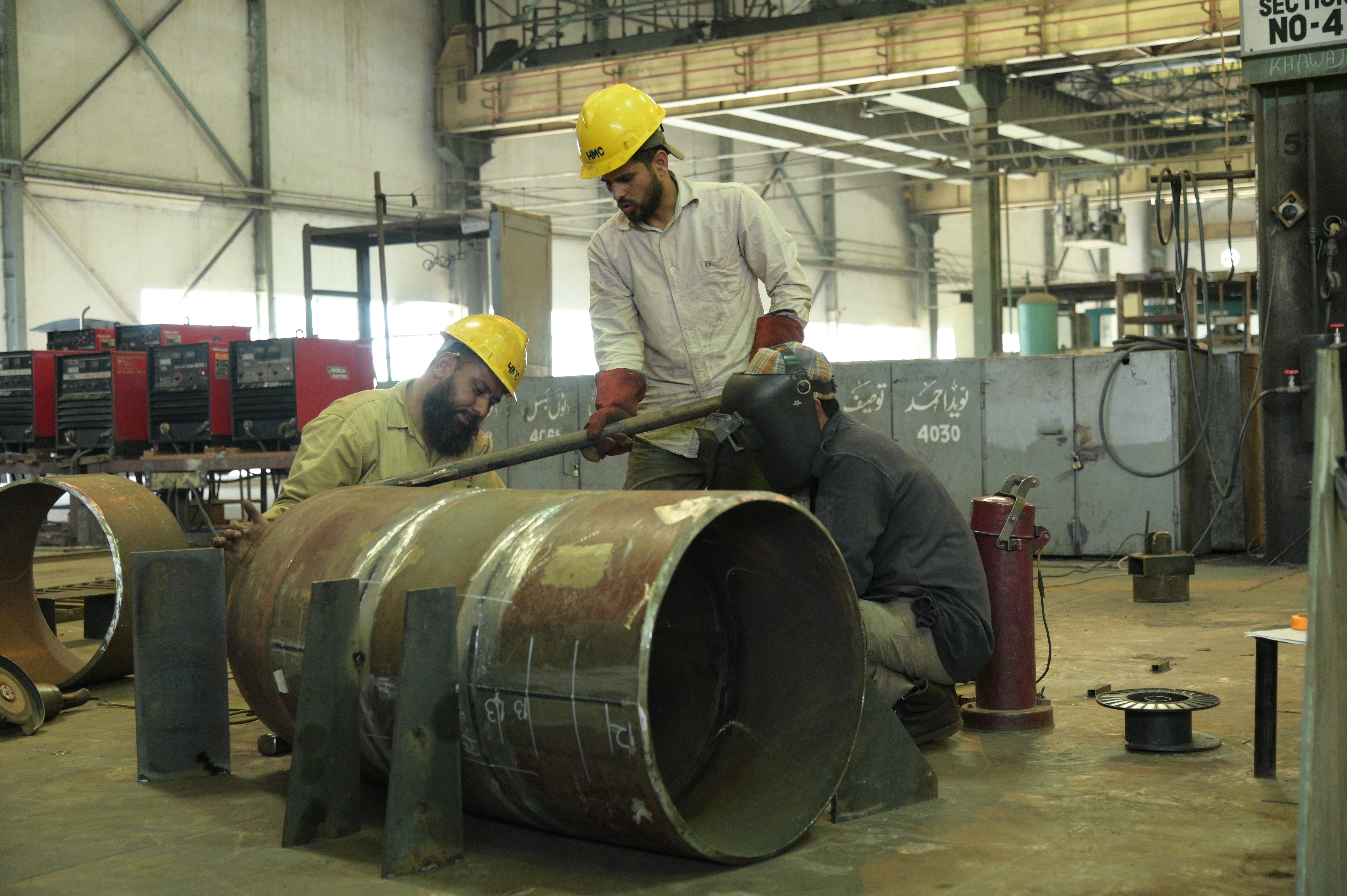 workers welding the large cylinders together