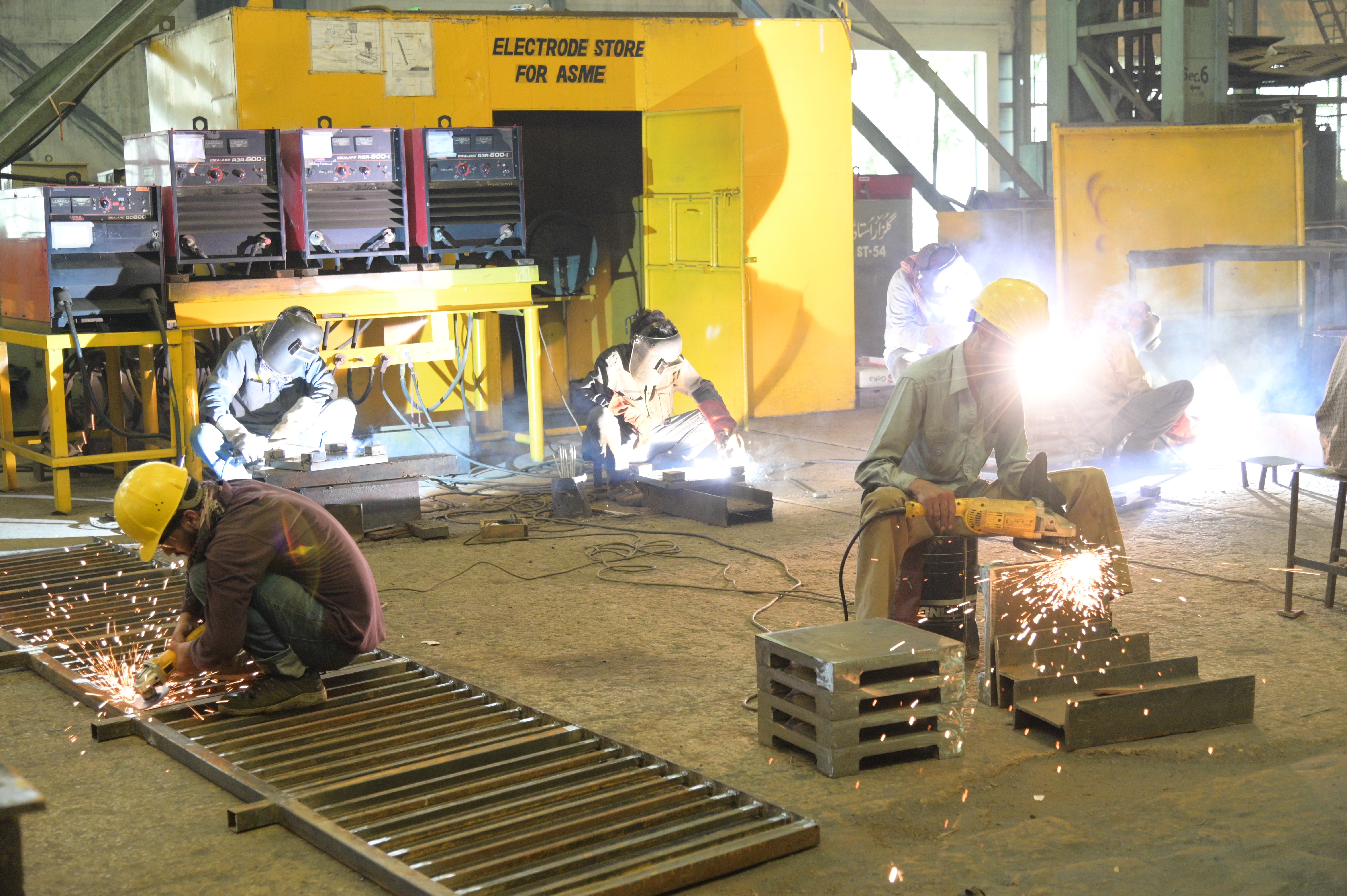 workers busy in cutting and welding the iron objects