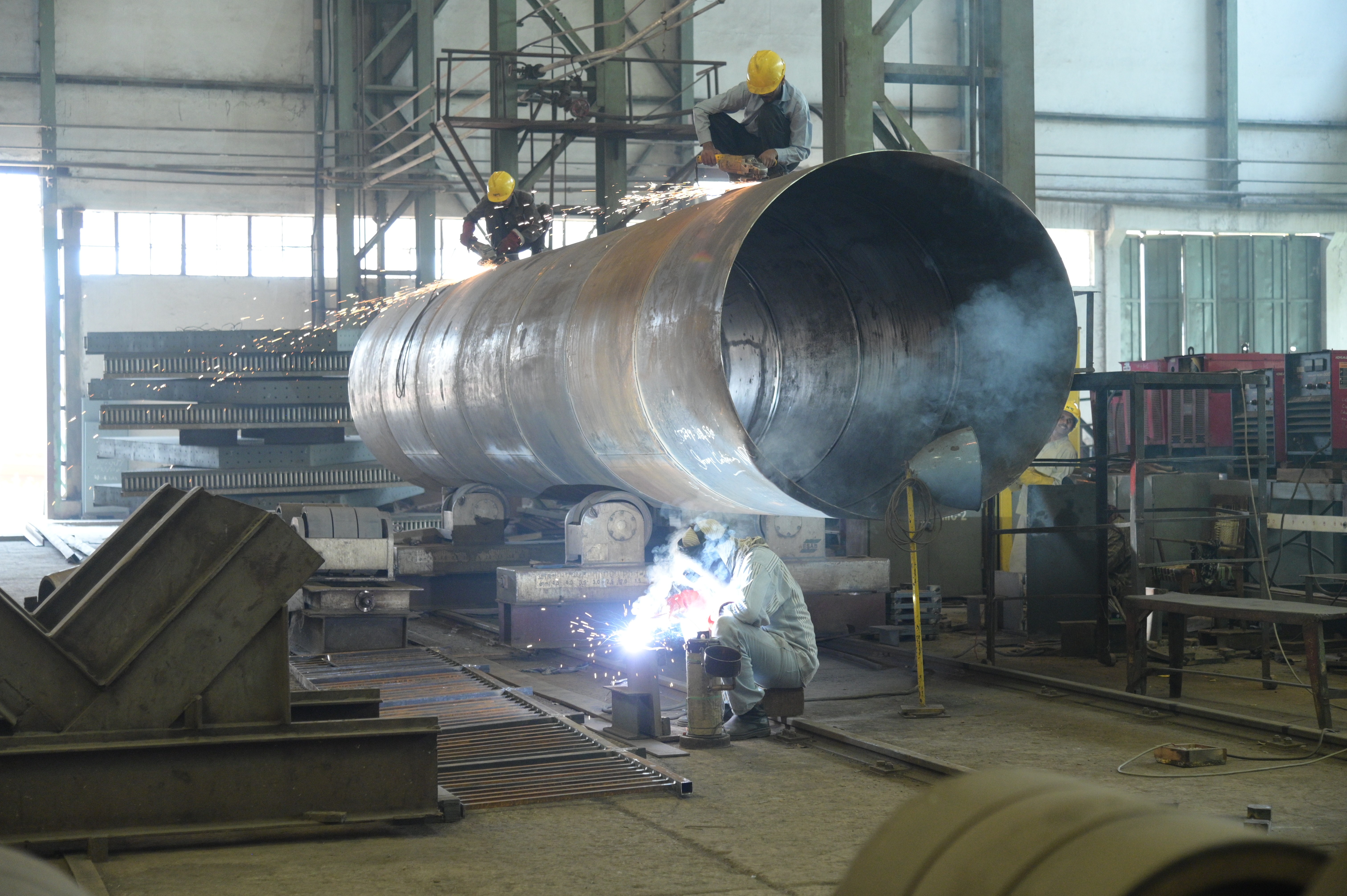workers busy in final finishing of the large cylinderical pipe