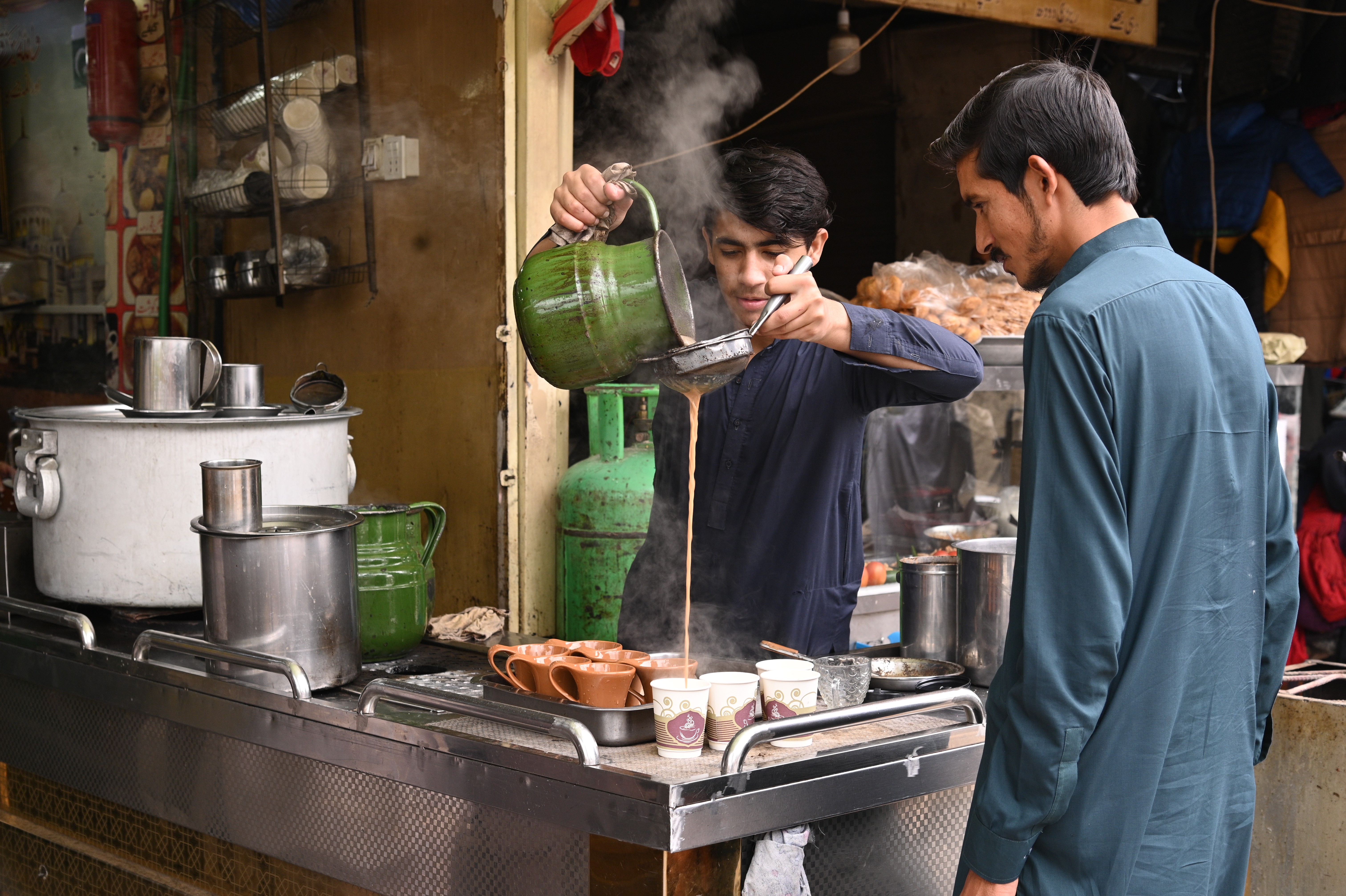 A boy with tea stall selling tea to the customers