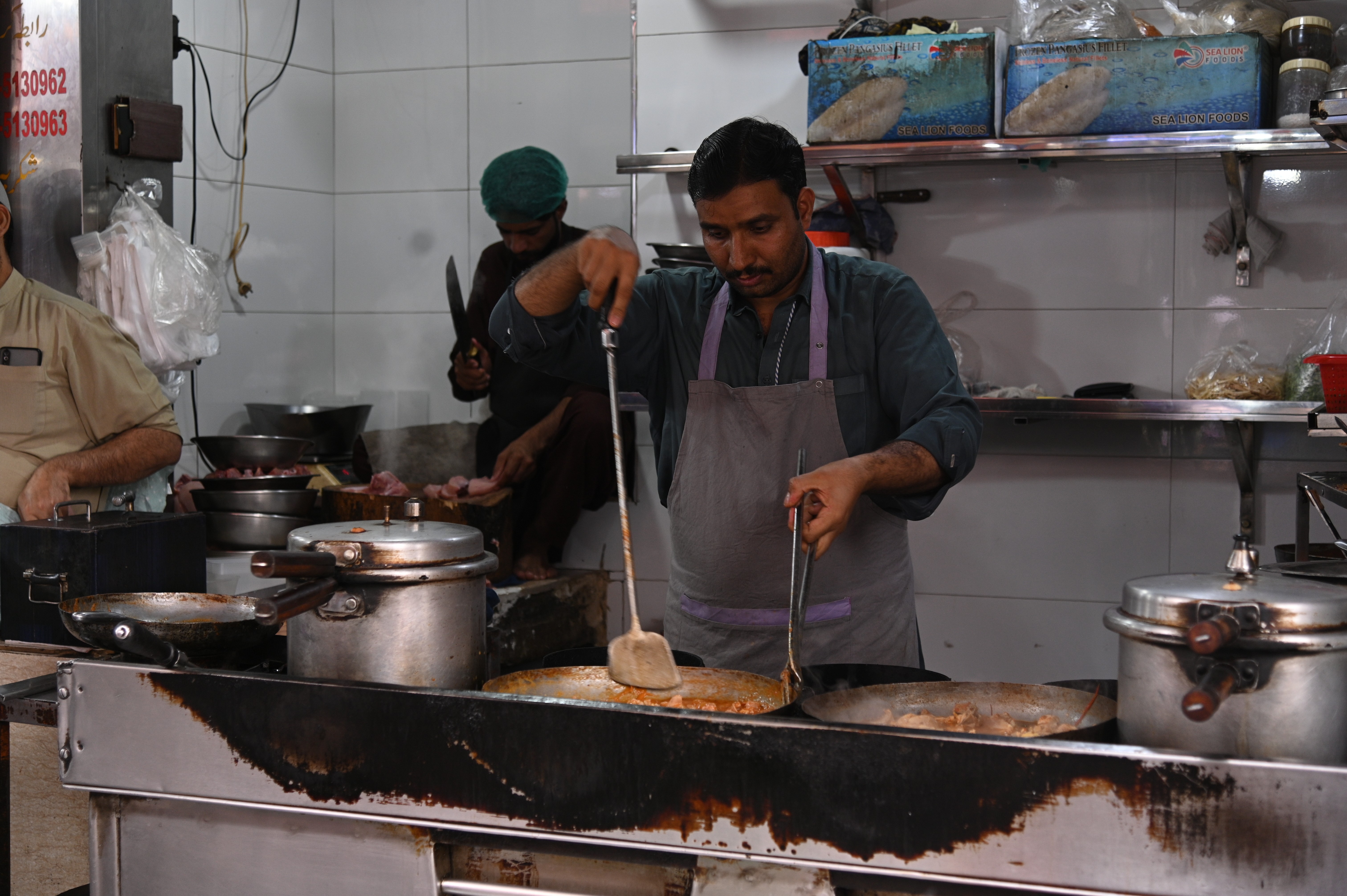 A chef busy in preparing chicken karahi