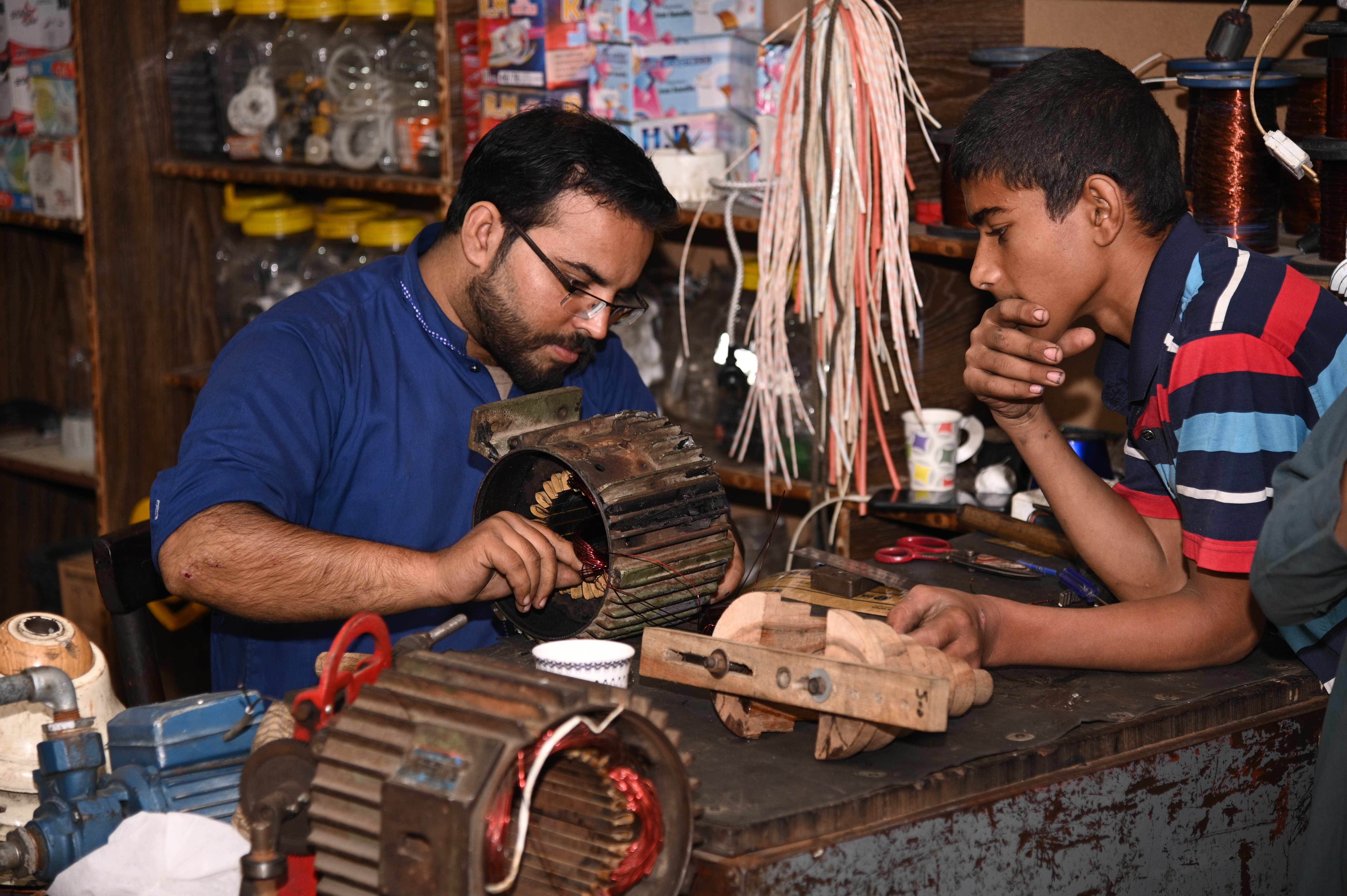 A man busy with his co-worker in fixing the electric motor