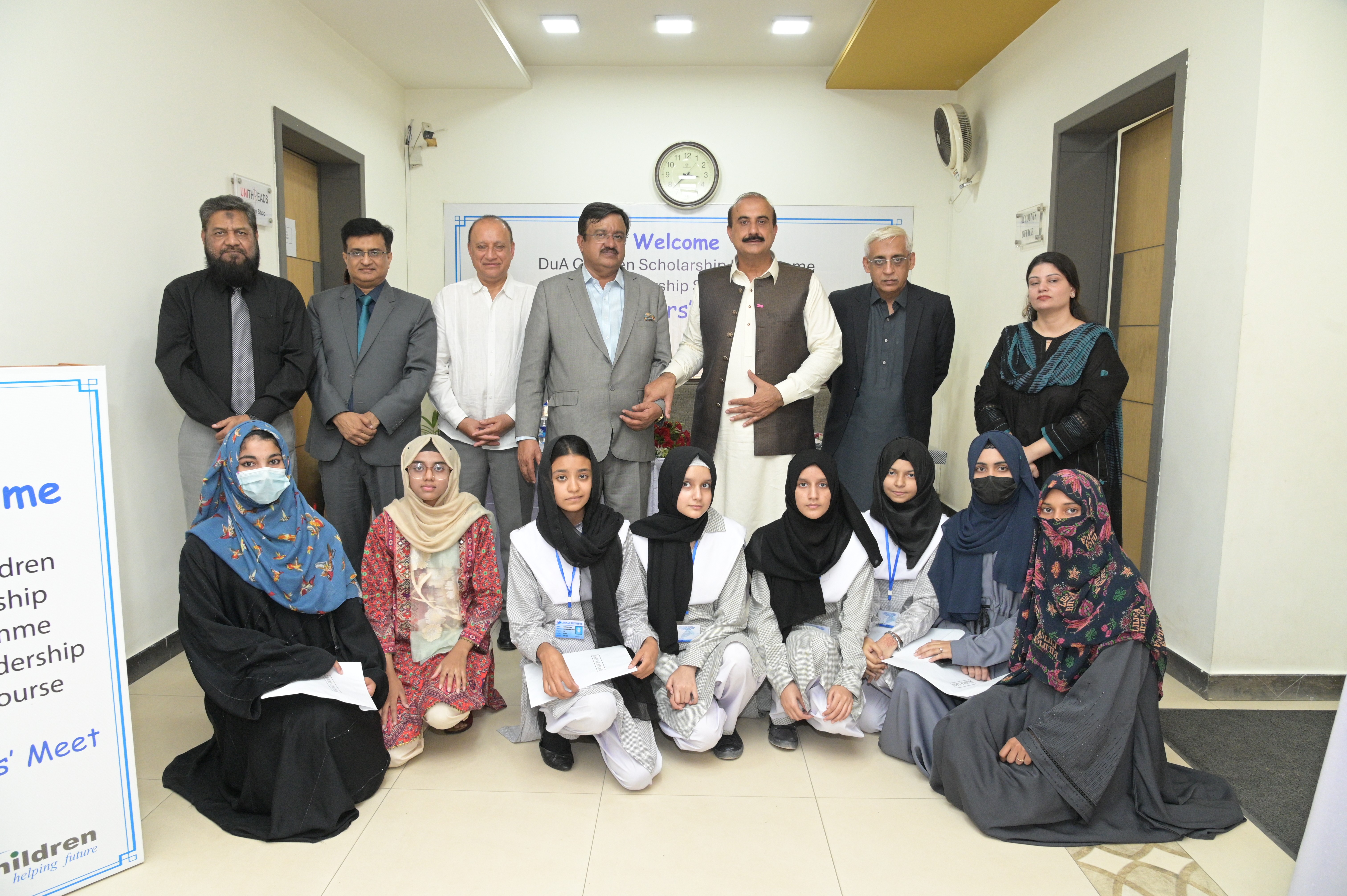 A group photo of scholarship-winning female students from various colleges with the organization leaders and chief guests