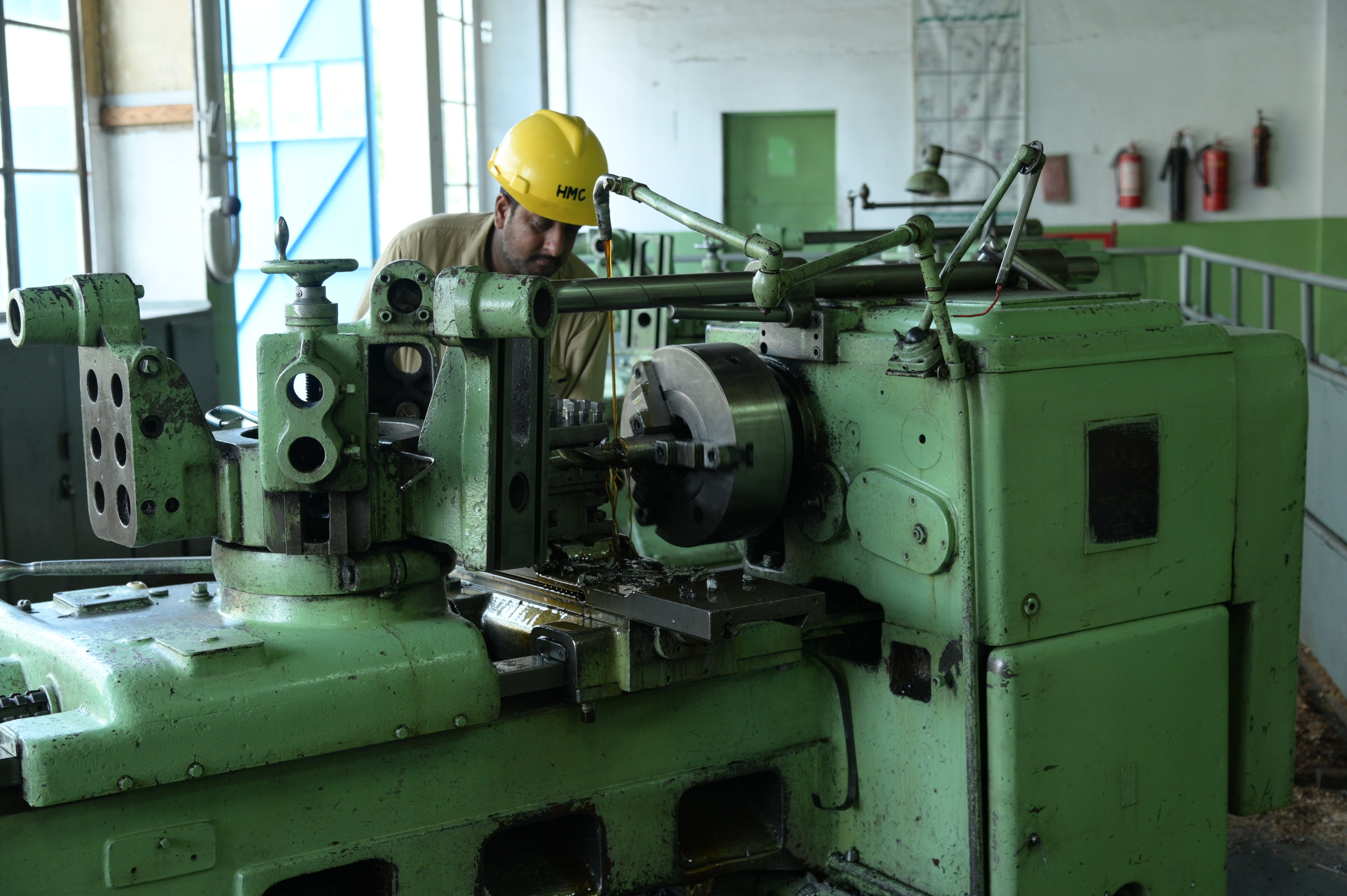 A worker lubricating the machine by using oil