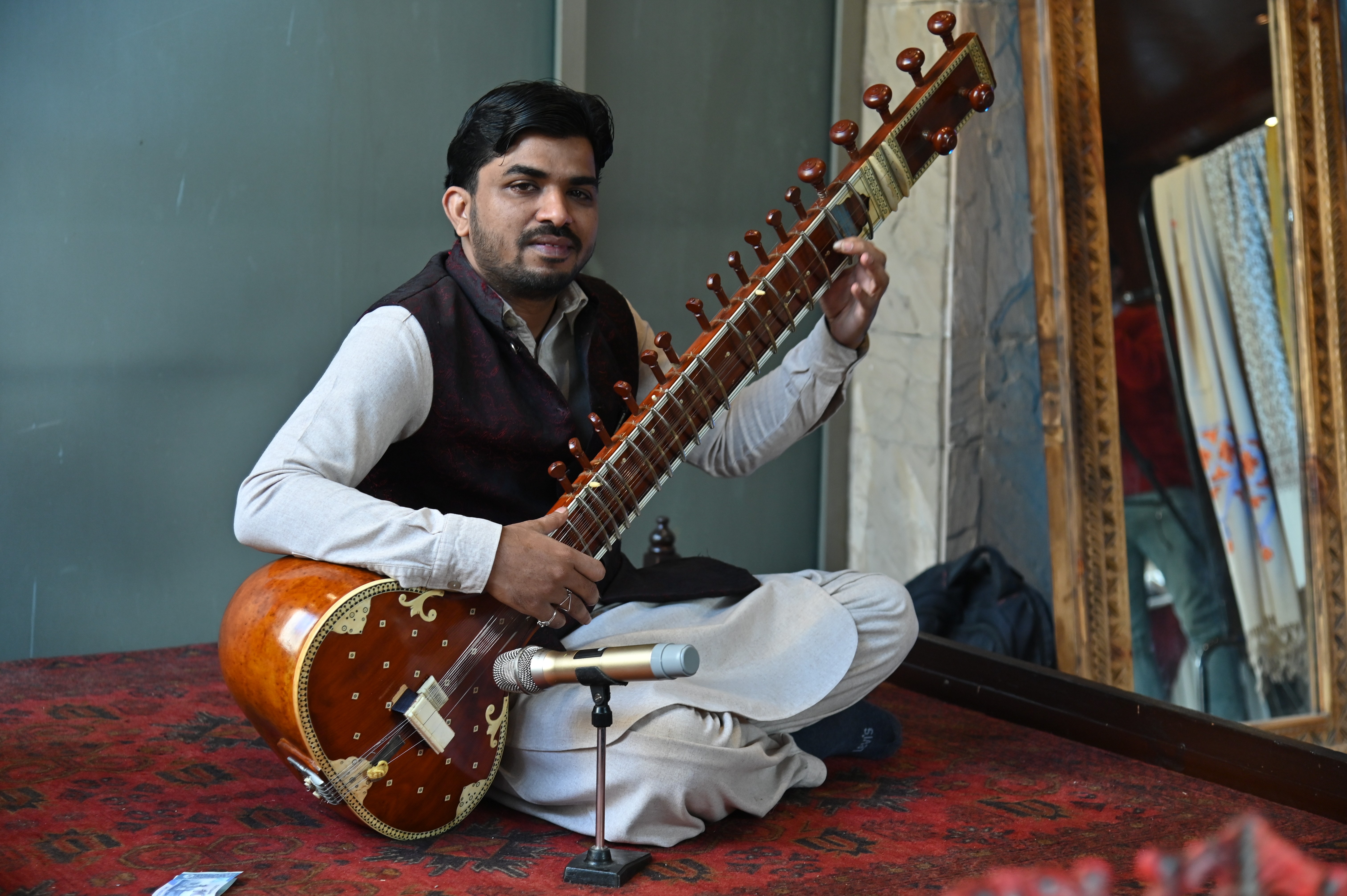 A musician playing Sitar: a plucked stringed instrument, originating from the subcontinent, flourished in the 18th century, and arrived at its present form in 19th-century.