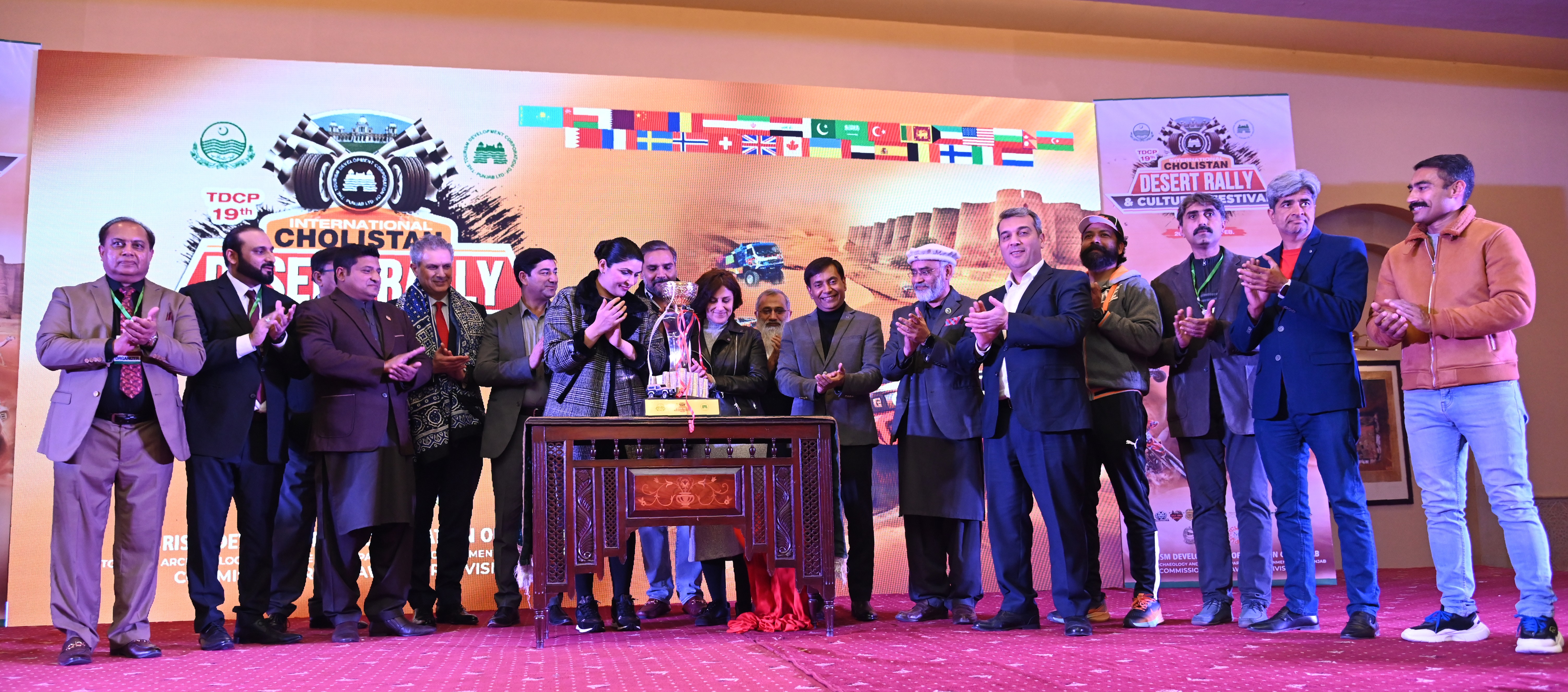 A group photo of chief guests and the participants with the  trophy