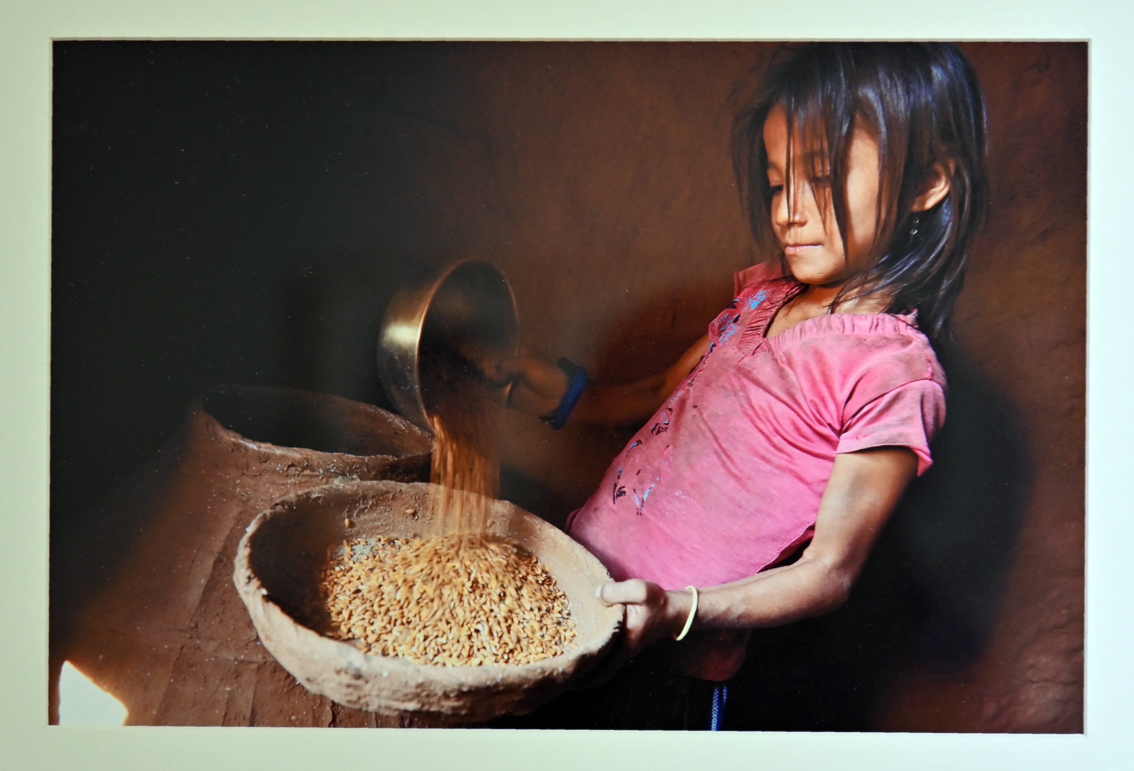 A girl taking out the grains to be grind in a mill