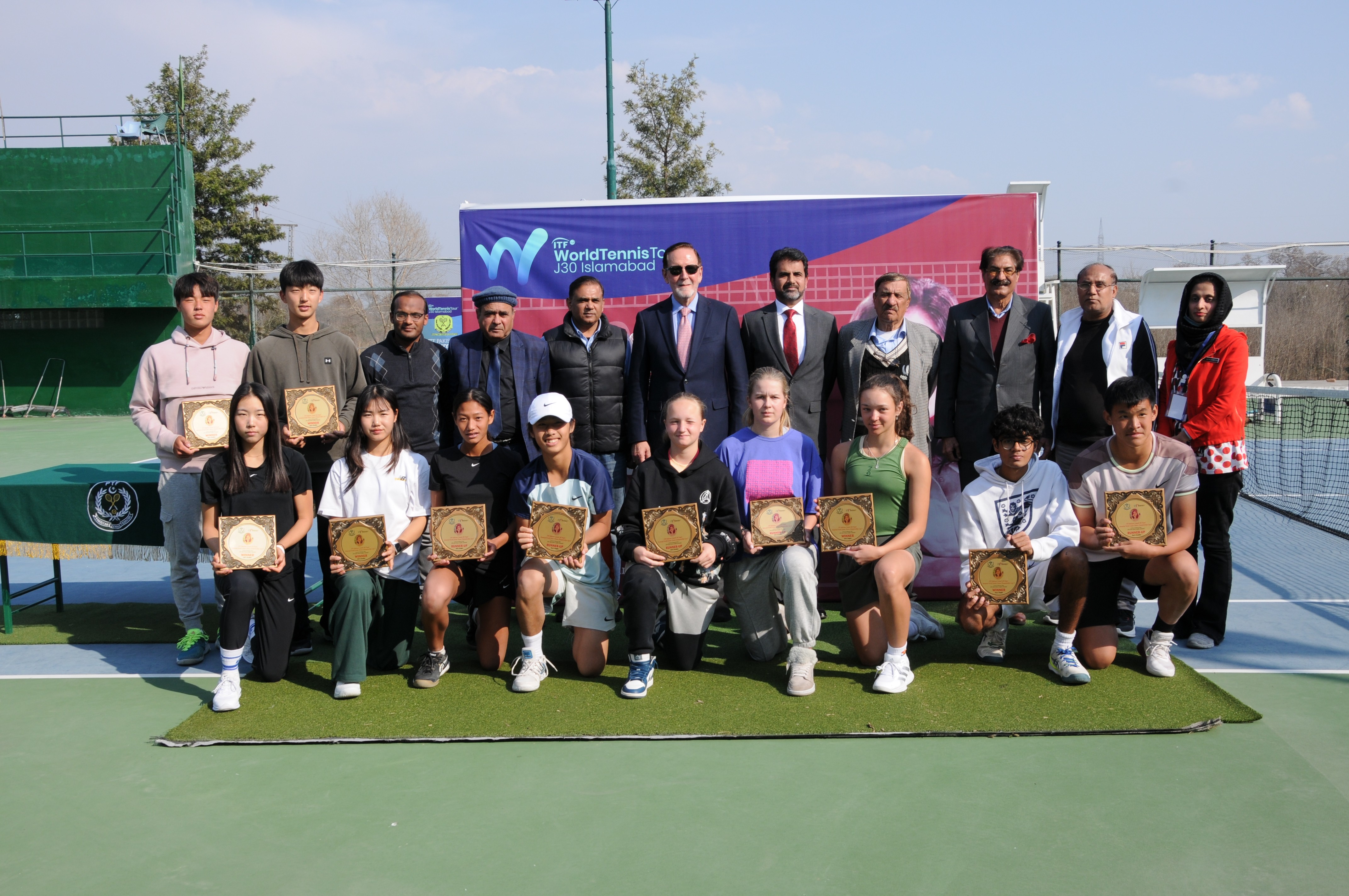 A group photo of winning tennis players with the chief guests