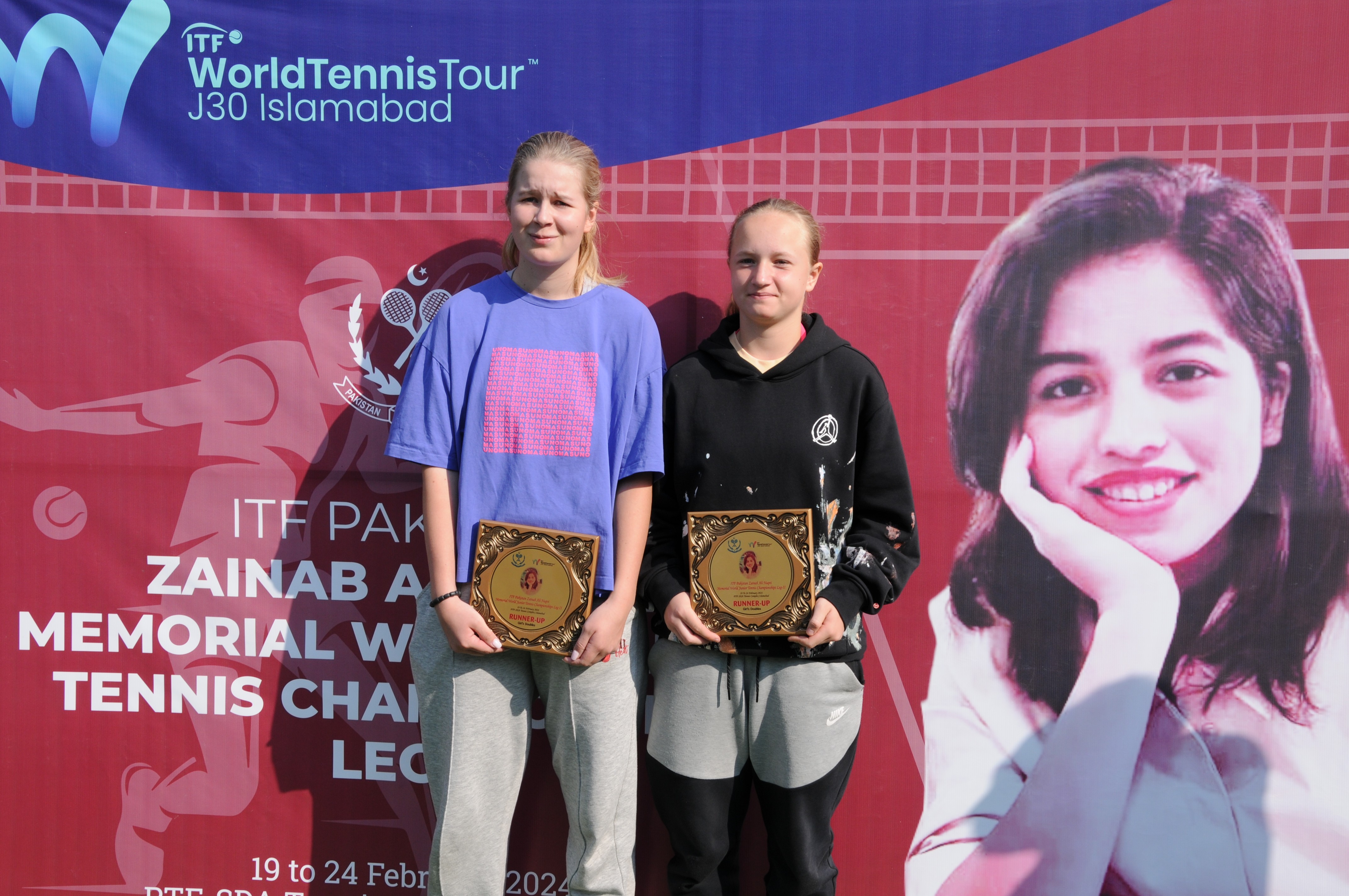 Tennis players posing with their winning trophy