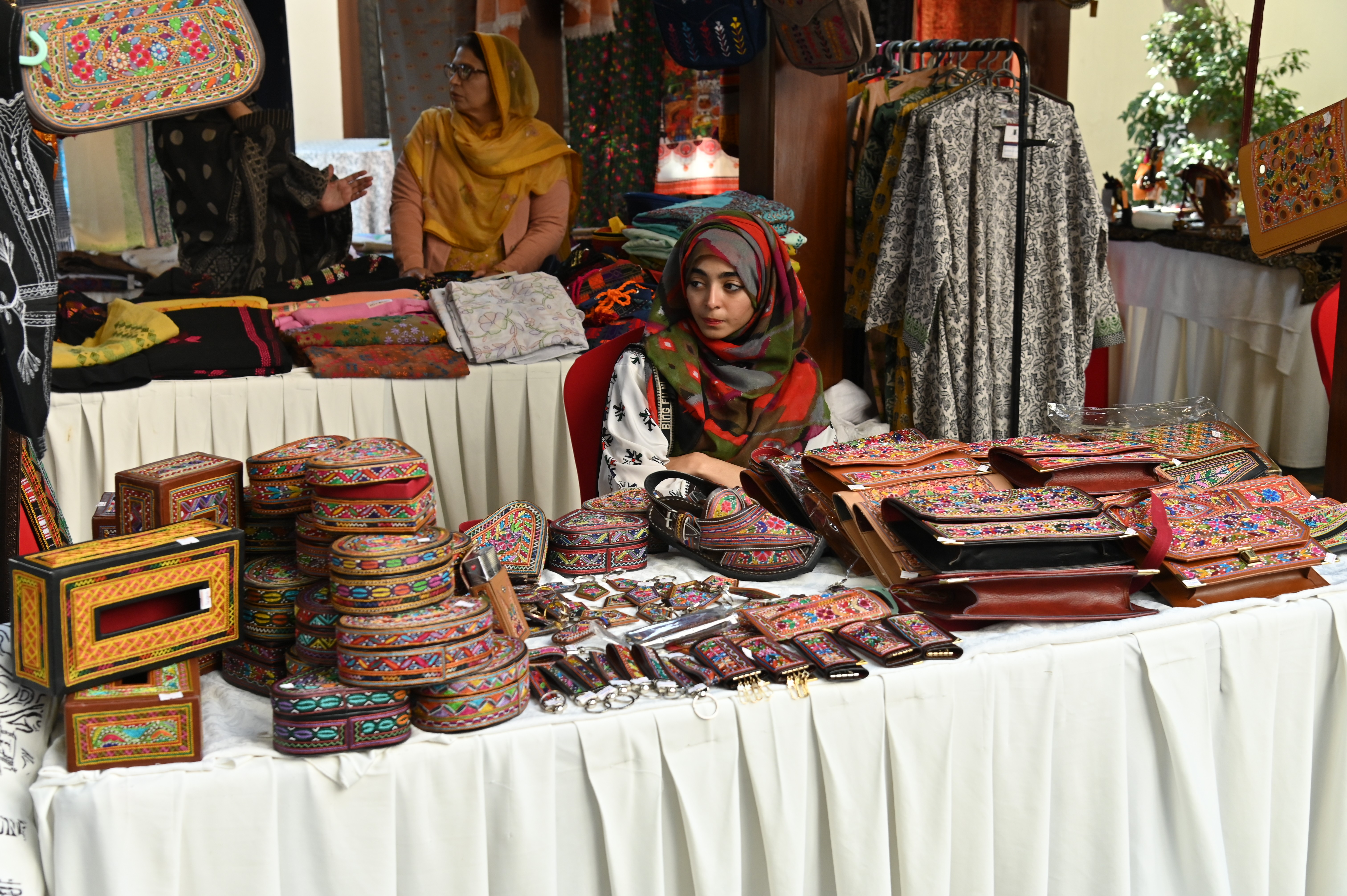A young girl selling various embroidered objects