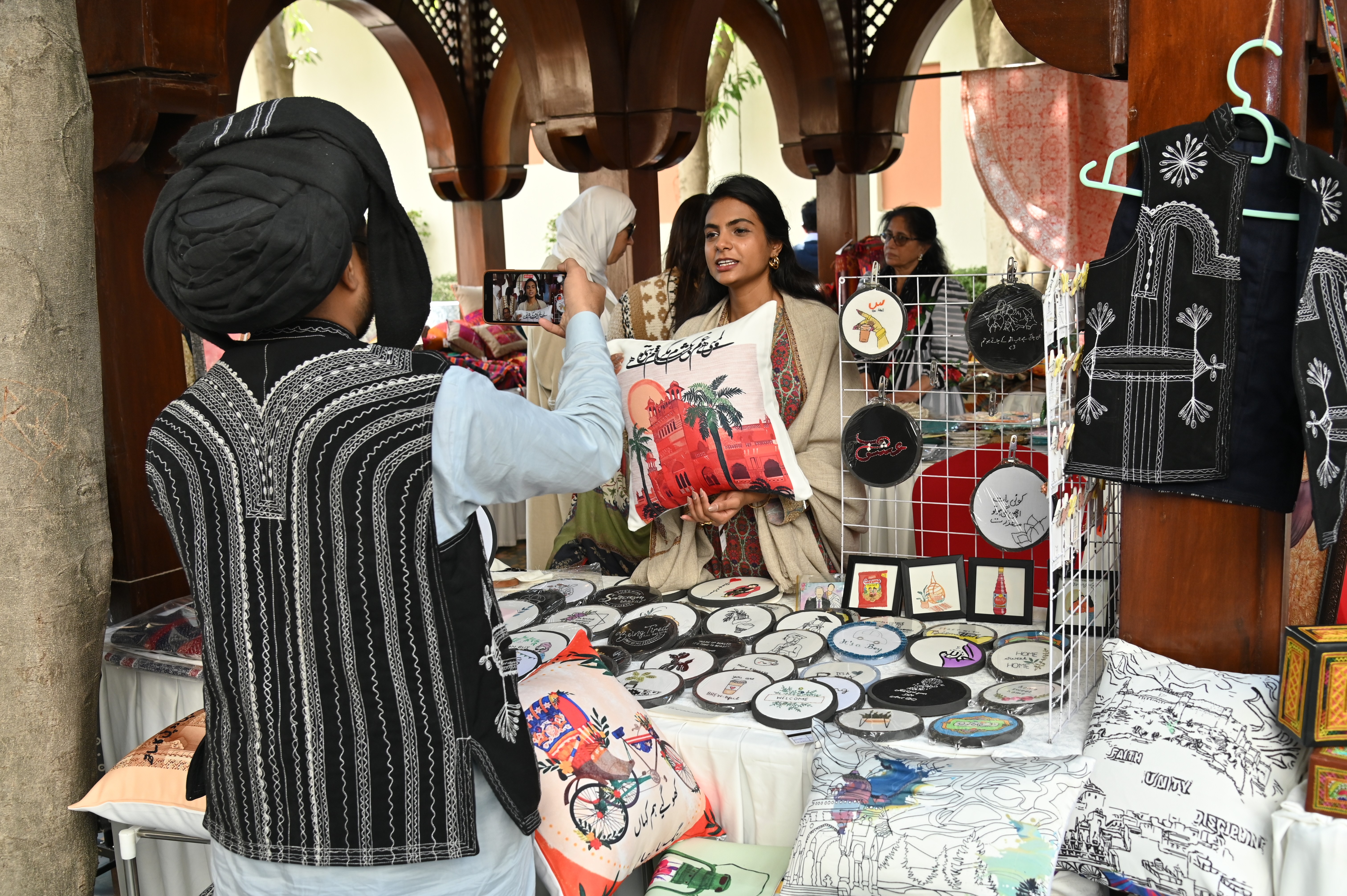 A young girl selling various embroidered frames