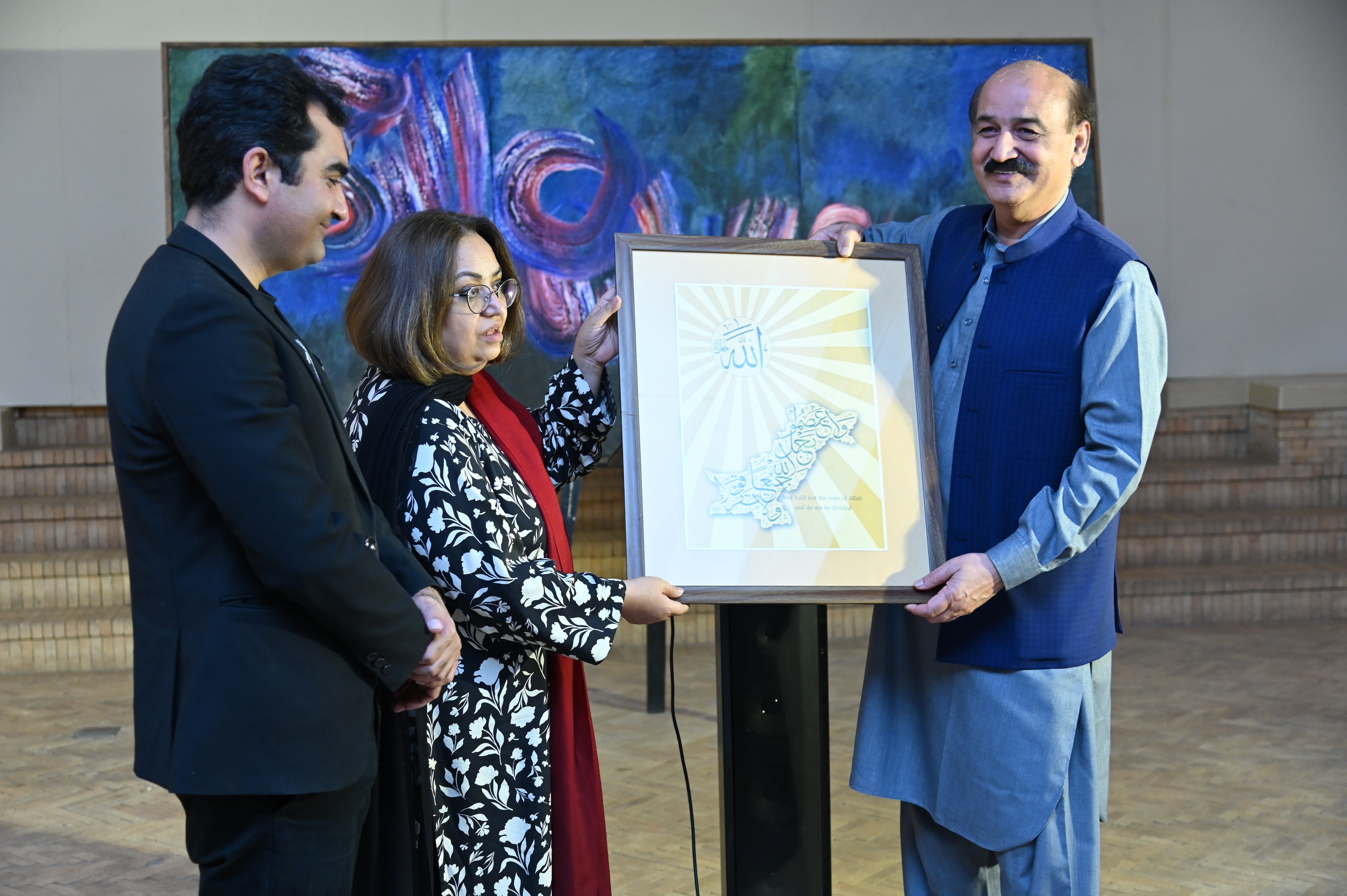 The Arabic calligraphy frame being presented to the guest of the event