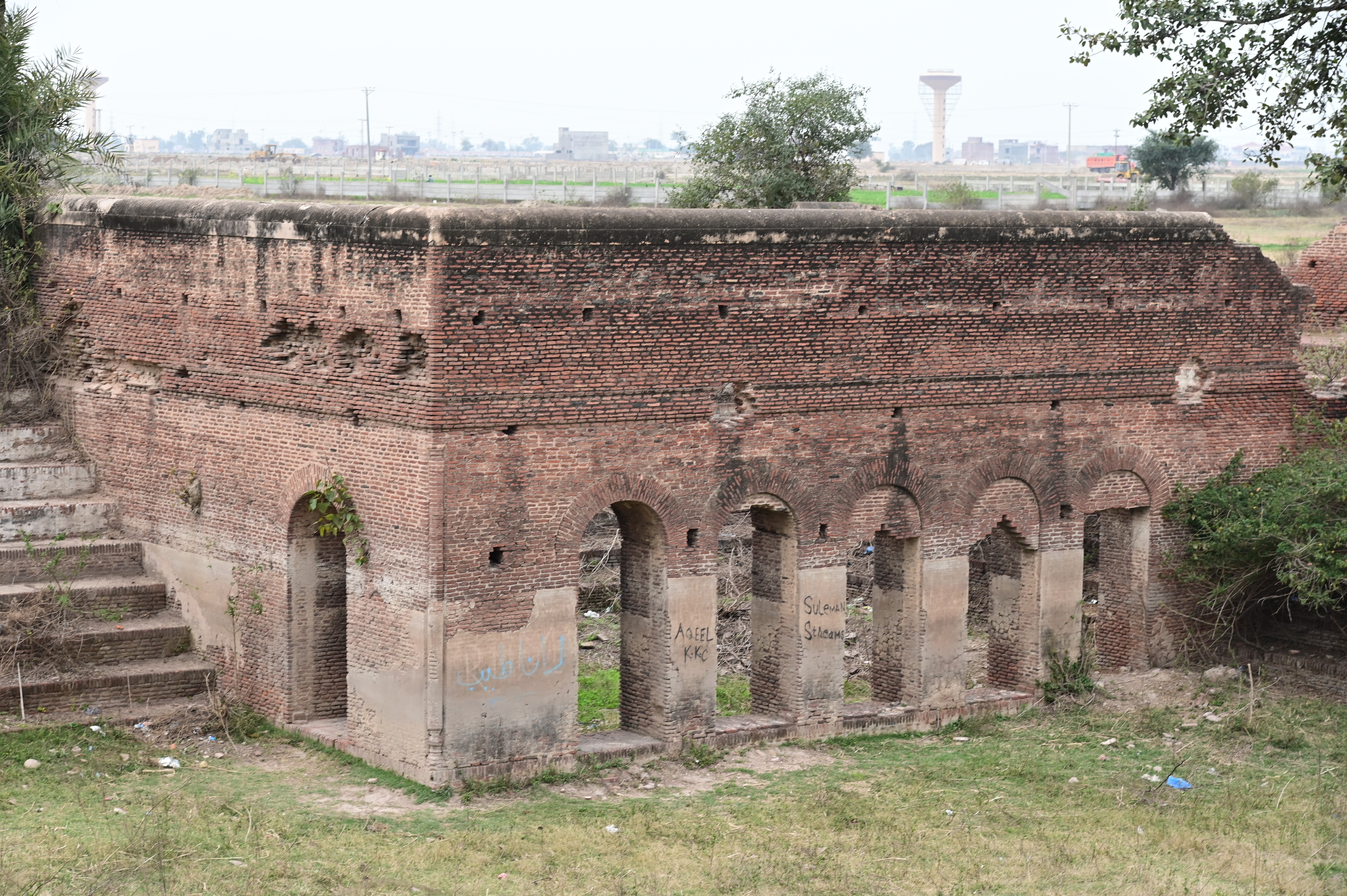 A close-up of an old brick structure with arched openings