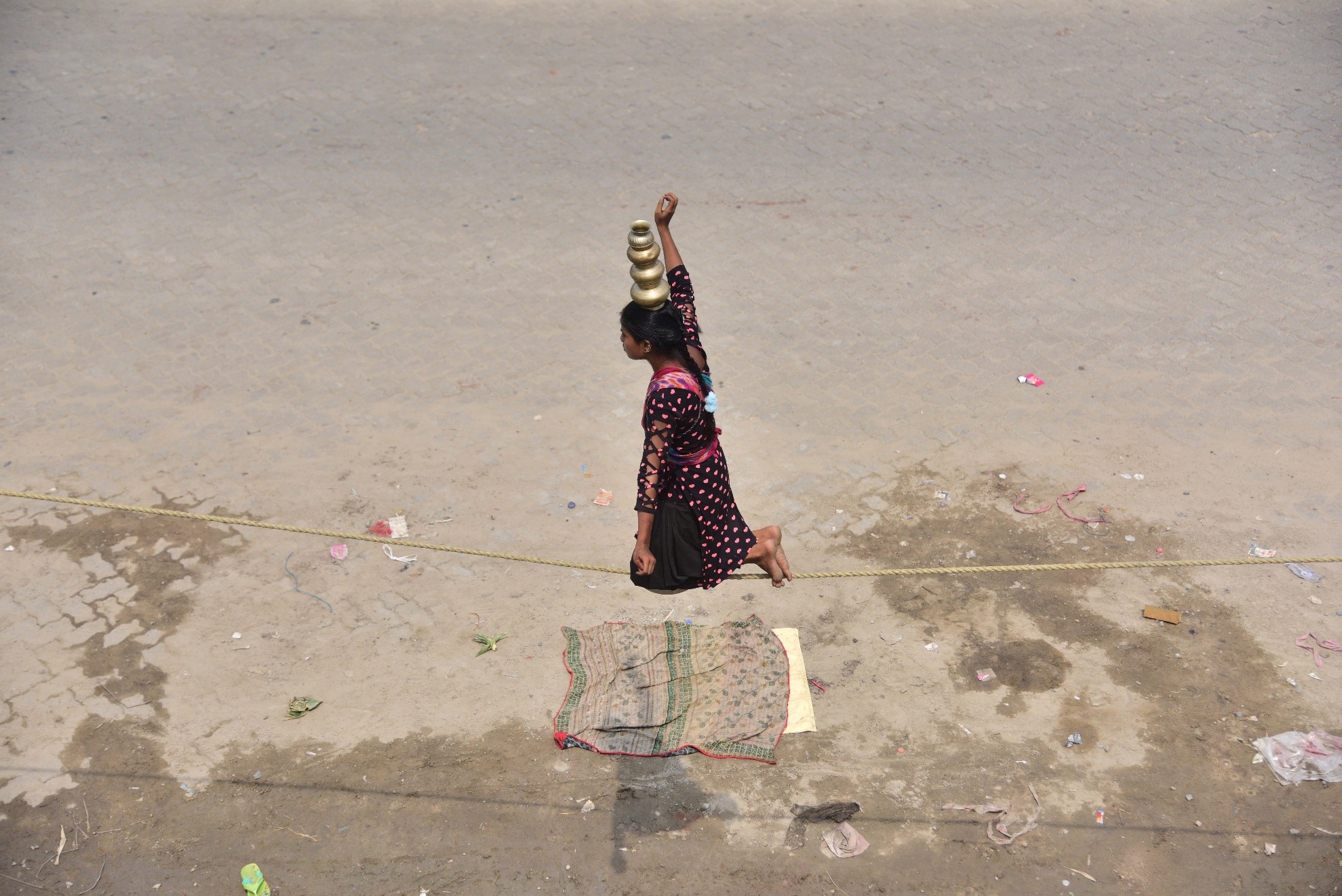 بھارت کی شمال مشرقی ریاست آسام کے ضلع ناگاؤں میں اسٹریٹ شو کے دوران ایک لڑکی رسی پر توازن برقراررکھنے کا مظاہرہ کر رہی ہے۔(شِنہوا)